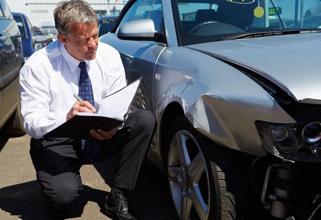 auto insurance claim form with pen and calculator